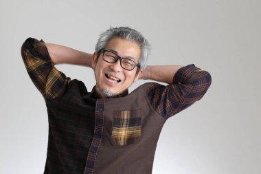 Beyaz arka planda duran kıdemli Asyalı adam.