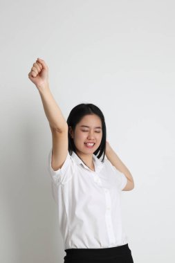 Üniversite üniformalı Asyalı kız beyaz arka planda duruyor..