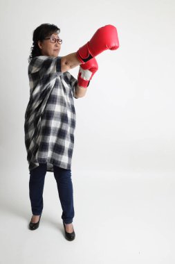 Beyaz arka planda duran yaşlı Asyalı kadın..