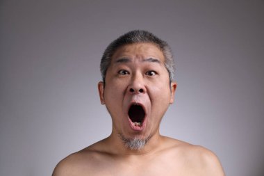 Gri arka planda Asyalı bir adamın portresi..