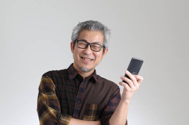 Beyaz arka planda duran kıdemli Asyalı adam.