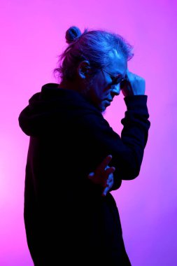 Beyaz arka planda jel renkli ışıkla poz veren Asyalı adam..