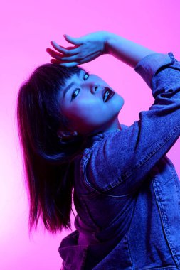 Beyaz arka planda jel renkli ışıkla poz veren Asyalı kadın..