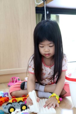 Odada oyuncak oynayan Asyalı kız..