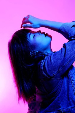 Beyaz arka planda jel renkli ışıkla poz veren Asyalı kadın..