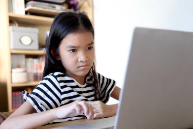 Asyalı kadın çocuğuna bilgisayar kullanmayı öğretiyor..