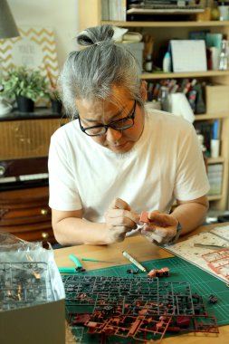 Asyalı adam plastik modeli hobisi olarak kullanıyor..