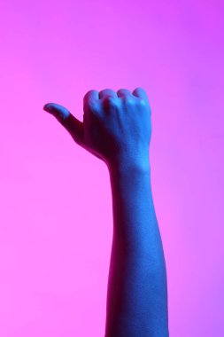 Asyalı adamın elleri beyaz arka planda canlı renklerle poz veriyor..