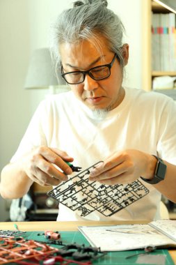 Asyalı adam plastik modeli hobisi olarak kullanıyor..