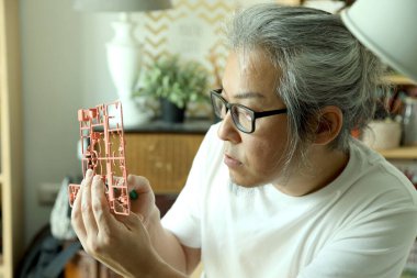 Asyalı adam plastik modeli hobisi olarak kullanıyor..