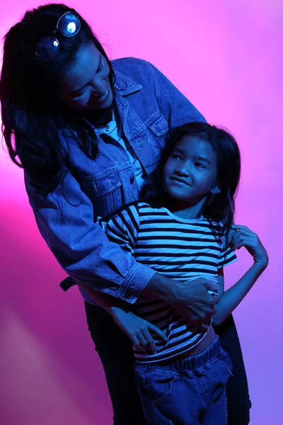 アジア人の母親と娘がカラージェルライトにポーズをとって — ストック写真