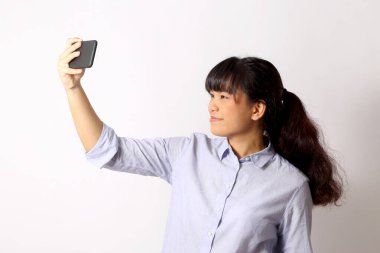 Beyaz arka planda poz veren Asyalı kadın..