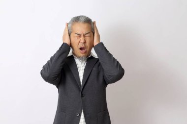 Asyalı adam beyaz arka planda kulaklarını kapatıyor..