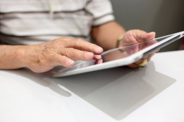 Tablet kullanan Asyalı yaşlı adam..