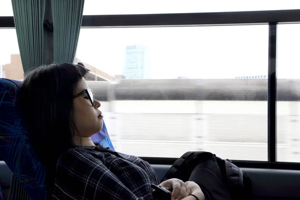 The Asian woman sleeping in the tour bus.