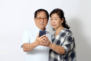 Beyaz arka plandaki yaşlı Asyalı çift..