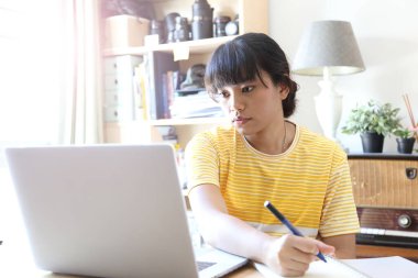 Ev stüdyosunda çalışan Asyalı kadın..