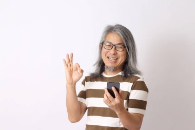 Beyaz arka planda duran kıdemli Asyalı adam..