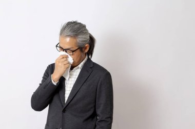 Beyaz arka planda hastalanan Asyalı adam..