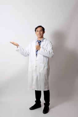 Beyaz arka planda duran Asyalı doktor..