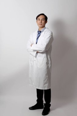 Beyaz arka planda duran Asyalı doktor..