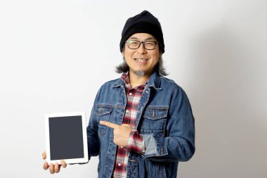 Beyaz arka planda duran kot gömlekli ve bereli Asyalı adam..