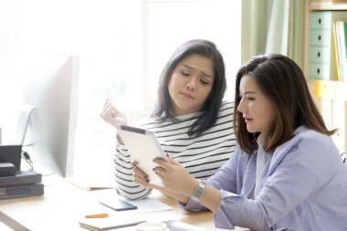 Tablet üzerinde çalışan Asyalı kadınlar..