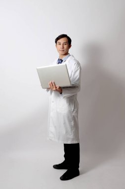 Beyaz arka planda duran Asyalı doktor..