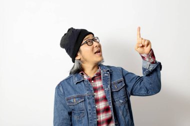 Beyaz arka planda duran kot gömlekli ve bereli Asyalı adam..