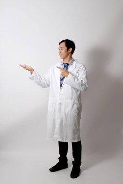 Beyaz arka planda duran Asyalı doktor..