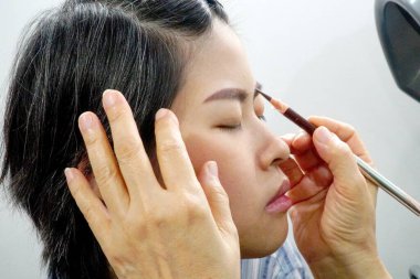 Asyalı kadının yüzüne kaş çiziyorum..