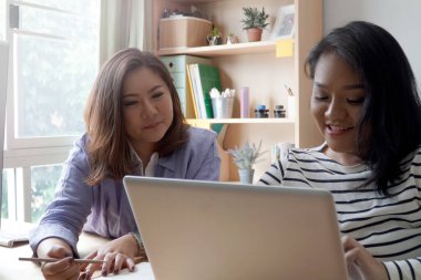 İki Asyalı kadın birlikte çalışıyor..