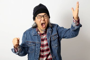 Beyaz arka planda duran kot gömlekli ve bereli Asyalı adam..