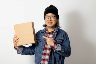 Beyaz arka planda duran kot gömlekli ve bereli Asyalı adam..