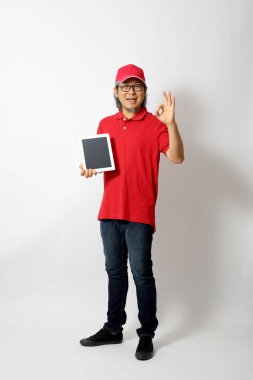 Kırmızı polo tişörtlü, kırmızı şapkalı Asyalı adam beyaz arka planda duruyordu..