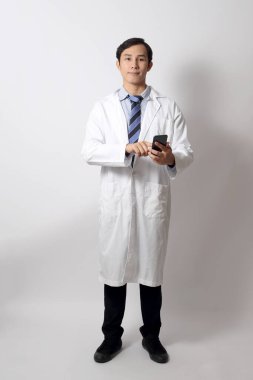 Beyaz arka planda duran Asyalı doktor..