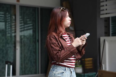 Güneydoğu Asyalı bir kadın umumi bir gezi için telefonunu kullanıyor..