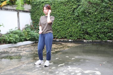 Güneydoğu Asyalı bir kadın antrenmana hazırlanmak için dijital cihazlarını kontrol ediyor..