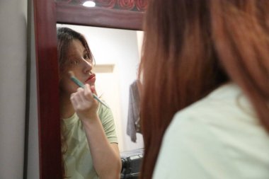 Güneydoğu Asyalı bir kadın dışarı çıkmak için makyaj yapıyor..