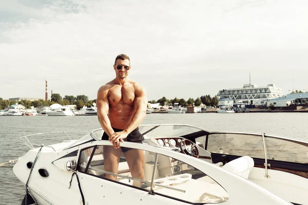Uomo muscolare su una barca — Foto Stock