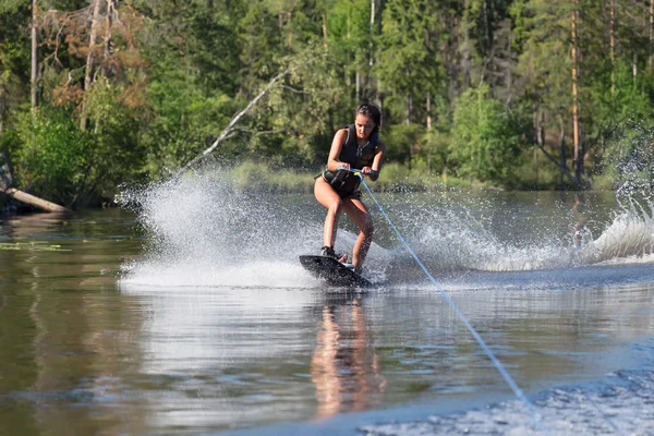 Kadın çalışma wakeboarding bir göl kenarında