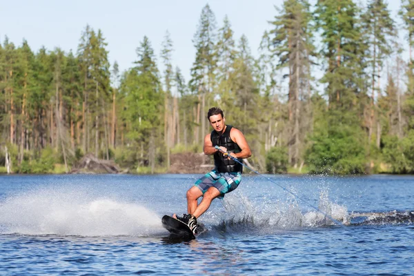 Young man riding wakeboard on summer lake — Stock Photo, Image
