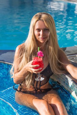 Genç sarışın kadın Yüzme Havuzu karpuz kokteyl ile güzel