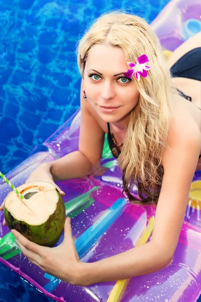 Unga vackra blonda kvinnan på luftmadrass swimmingpool — Stockfoto