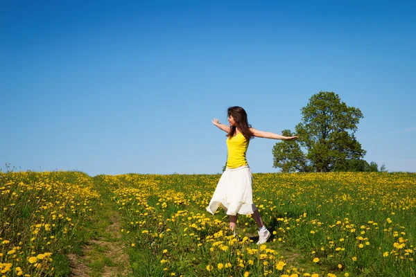 Jeune femme sur une prairie de pissenlit printemps temps — Photo