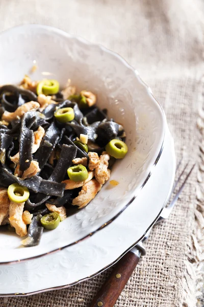 Pasta nera con pollo e olive verdi — Foto Stock