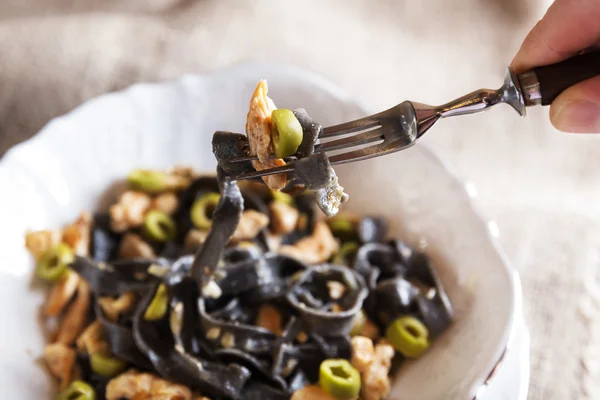 Pasta nera con pollo e olive verdi — Foto Stock