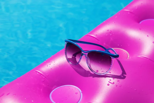 Gafas de sol rosa colchón de aire piscina. Concepto tropical — Foto de Stock