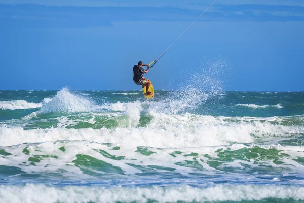 Atletik adam uçurtma sörf tahtası üzerinde deniz dalgaları sürme — Stok fotoğraf