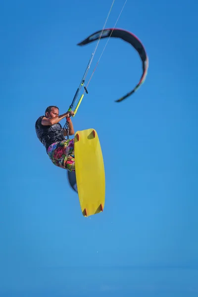 Hombre atlético cabalgando en tabla de kitesurf en olas marinas — Foto de Stock